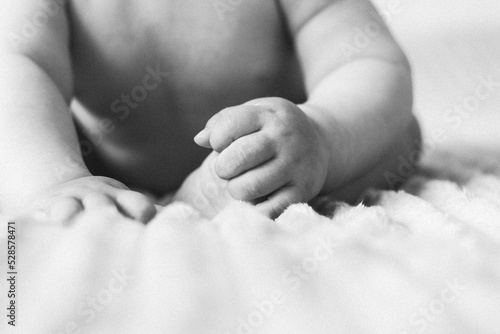 black and white photo. Children's leg with hand