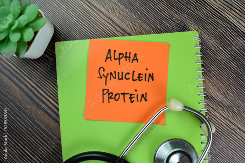 Concept of Alpha Synuclein Protein write on sticky notes isolated on Wooden Table. photo