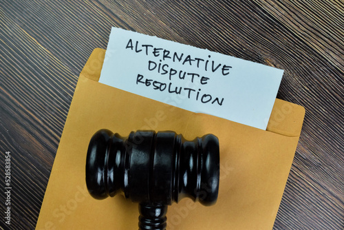 Alternative Dispute Resolution text on document with gavel above brown envelope. photo