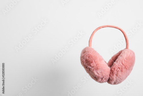 Stylish winter earmuffs on white background, space for text