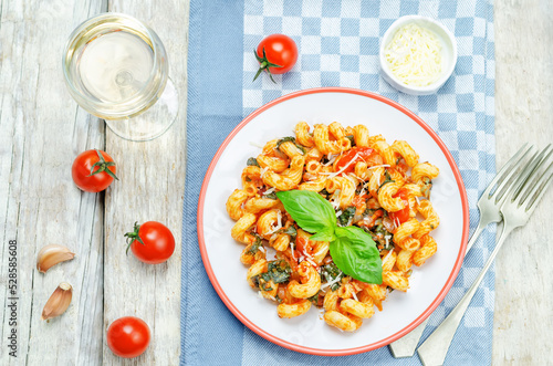 Tomato basil pasta in a plate on a wood background