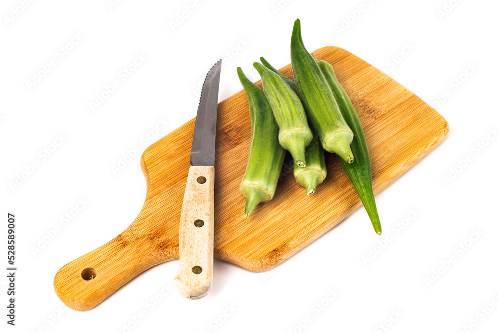green okra pods on cutting board with a knife. Isolated on white. green okra pods on cutting board with a knife. Isolated on white.