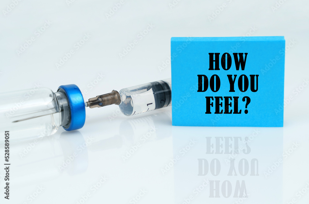 On a white reflective surface there is a syringe with an ampoule and a plate with the inscription - How Do You Feel On a white reflective surface there is a syringe with an ampoule and a plate with the inscription - How Do You Feel