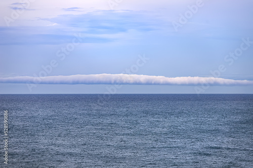 A rare roll cloud phenomenon, a type of arcus cloud that appears like a tube horizontally along the horizon photo