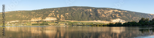 Peaceful View of Wood Lake with Reflection on the water and mountains in background. Lake Country, Okanagan, British Columbia, Canada. Sunrise