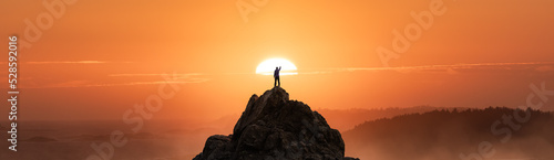 Adventurous Man Hiking on the Rocky Coast with Mountains and Dramatic Sunset Sky. Adventure Composite. 3d Rendering Rocks. Background from West Coast of British Columbia, Canada.