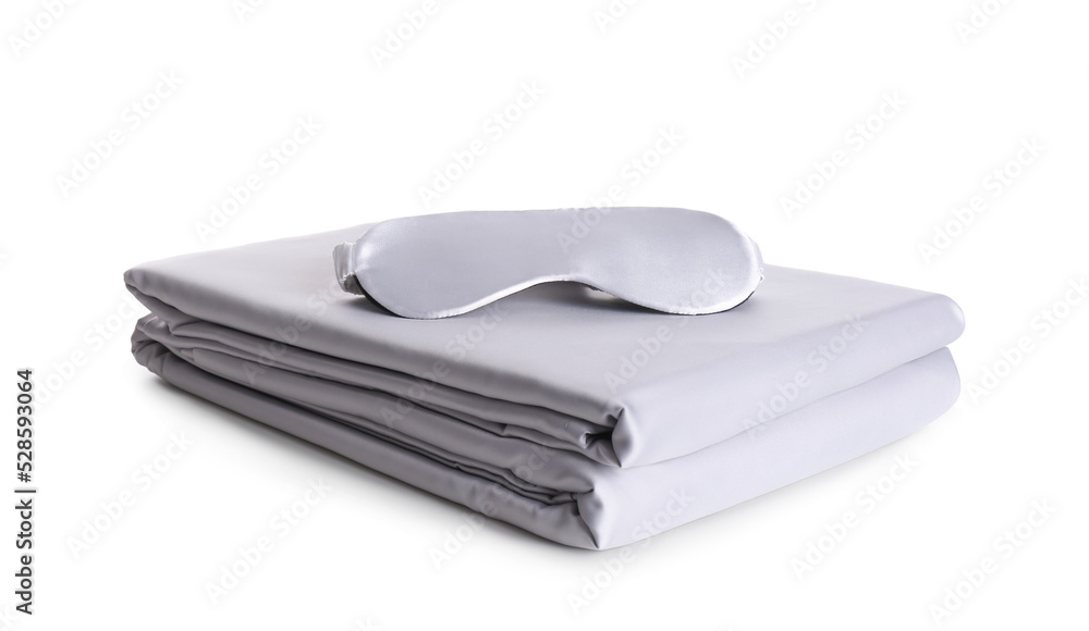 Stack of clean silky bed linen and sleeping mask isolated on white Stack of clean silky bed linen and sleeping mask isolated on white
