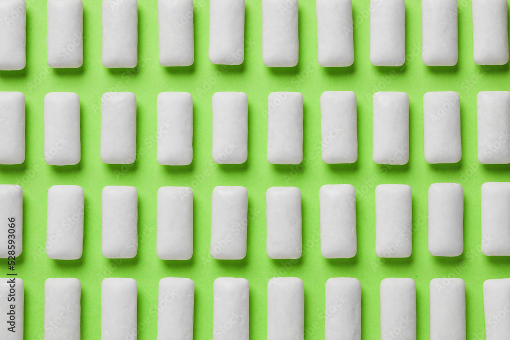 Many chewing gum pieces on green background, flat lay Many chewing gum pieces on green background, flat lay