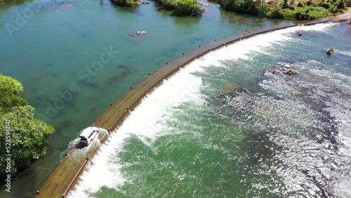Aerial landscape view of a car driving on Ivanhoe Crossing a concrete causeway on Ord River near Kununurra, Western Australia. photo