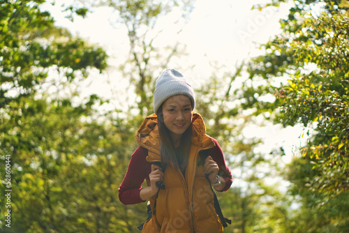 秋の紅葉をハイキングする女性