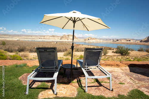 Lounge chairs with an umbrella overlooking Lake Powell in Page, Arizona © L.I. Drone Shots 