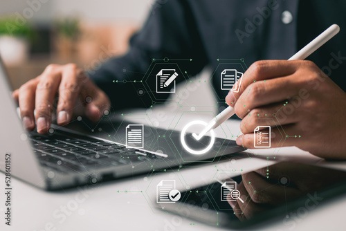 Canvastavla The proper sign for approving an e-document and guaranteeing quality control is made by a businessman using a stylus pen on a digital tablet with a virtual document