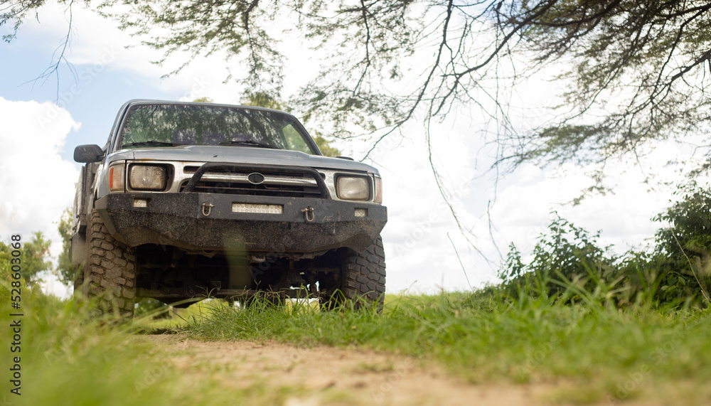 Fototapeta premium 4X4 VEHICLE ON OFFROAD ROUTE IN THE MIDDLE OF THE COUNTRYSIDE, OUTDOORS
