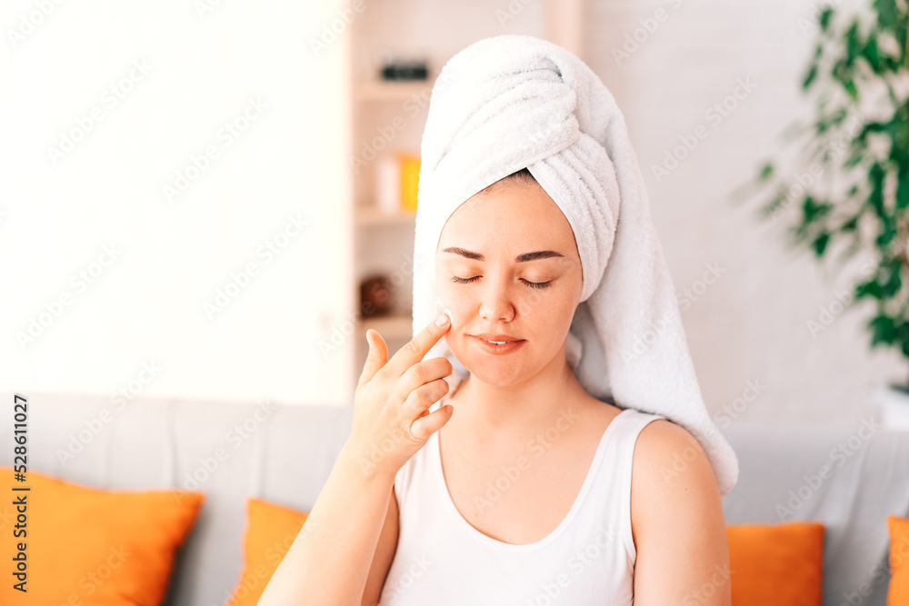 A happy woman engaged in the usual skin care at home with the help of cosmetics. The concept of skin care at home. A happy woman engaged in the usual skin care at home with the help of cosmetics. The concept of skin care at home.