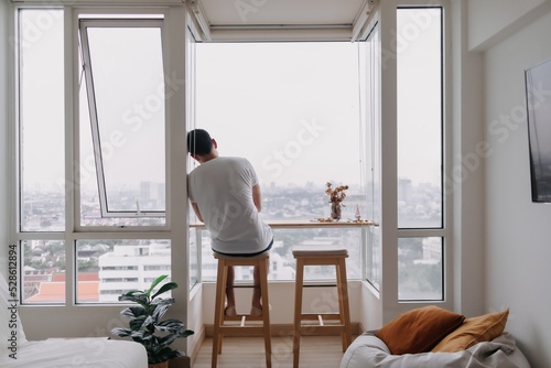 Lonely asian man sit by windows in the room. Concept lonely single broken heart. © Sevendeman