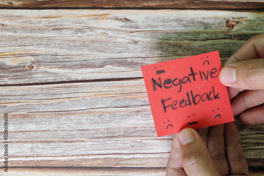 How to handle customer negative feedback concept. Hand holding red note with written word with copy space.