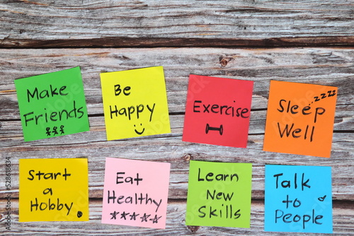 Obraz na płótnie Healthy lifestyle and physical, emotional, mental social and intellectual wellbeing concept. Colorful sticky notes reminder set in wooden background with copy space. w salonie