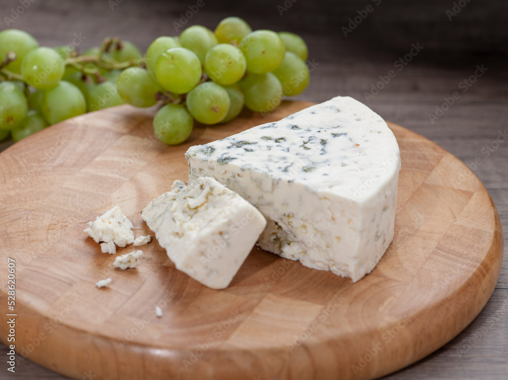 Blue Cheese on wooden cutting board with grapes