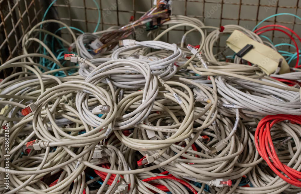 Alte Netzwerkkabel und Stromkabel in einer Gitterbox zur Entsorgung gelagert Alte Netzwerkkabel und Stromkabel in einer Gitterbox zur Entsorgung gelagert