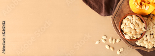 Photos Bowl with natural pumpkin seeds on beige background with space for text, top vie