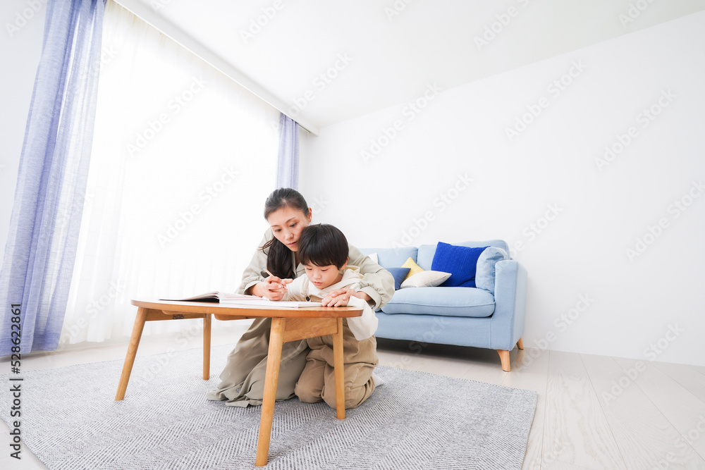 家でお母さんと一緒に勉強をする男の子 家でお母さんと一緒に勉強をする男の子