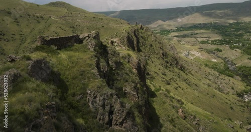 Fast Flyover Historical Site Of Tmogvi Fortress Ruins In Gorges Over Kura River In Georgia. Aerial Drone Shot photo