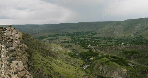 Tmogvi Fortress Ruins On Top Of Huge Rocky Massif In Aspindza, Georgia. aerial pullback photo