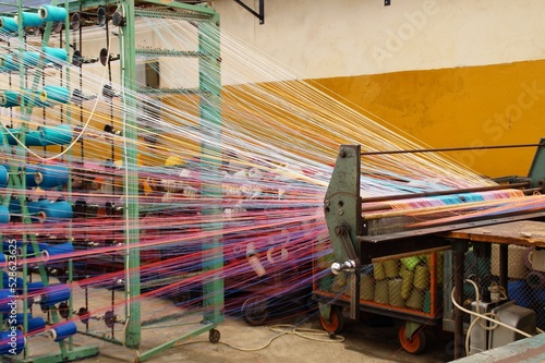 colored linen warp threads on a weaving machine photo