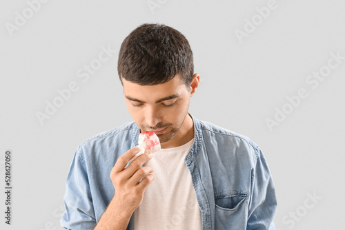 Young man wiping nosebleed ...