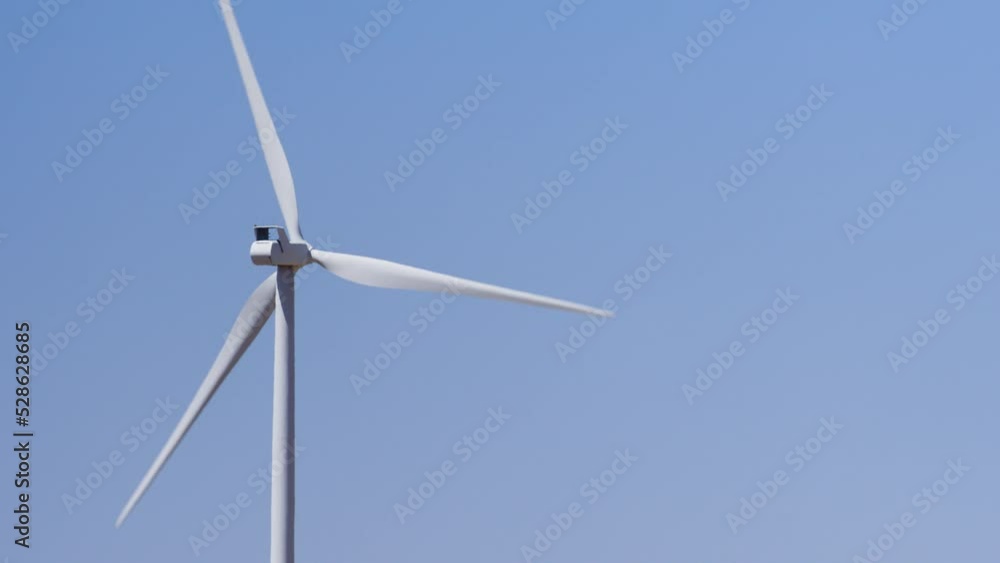 A moving wind turbine in the hot Idaho desert. The turbine provides energy to homes, farms, and water pumps that water the dry desert area that grows potatoes, alfalfa, hay, and other items. 4K. A moving wind turbine in the hot Idaho desert. The turbine provides energy to homes, farms, and water pumps that water the dry desert area that grows potatoes, alfalfa, hay, and other items. 4K.