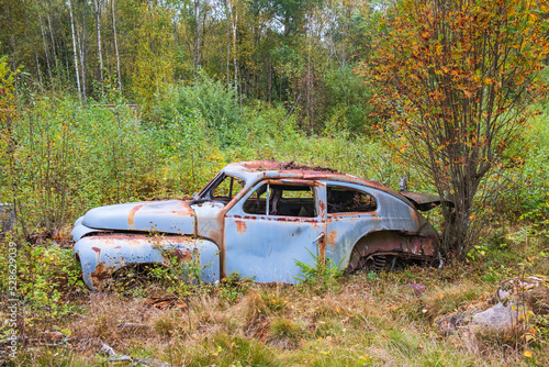 Old rusty car left in the woods
