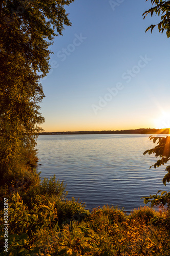 Sunset scenery on an autumn evening in Finland. Lake shore wallpaper concept image. Some flare effect added to images.