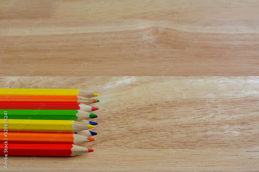 Color pencils on light brown wooden table background. Color pencils on light brown wooden table background.