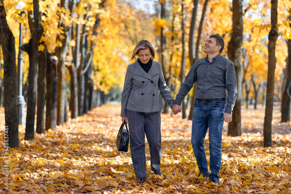 portrait of a romantic couple in an autumn city park, a man and a woman walking and posing against the background of yellow maple leaves, a bright sunny day portrait of a romantic couple in an autumn city park, a man and a woman walking and posing against the background of yellow maple leaves, a bright sunny day