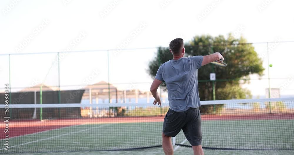 Rear view of young male tennis player during game or workout Rear view of young male tennis player during game or workout