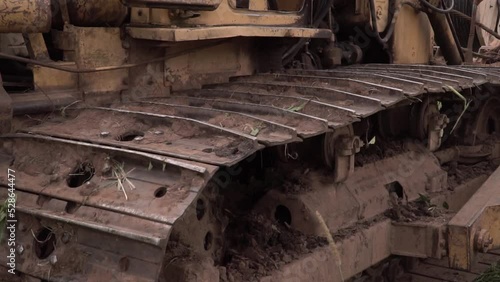 Close up view on bulldozer's undercarriage during pushing ground at construction site