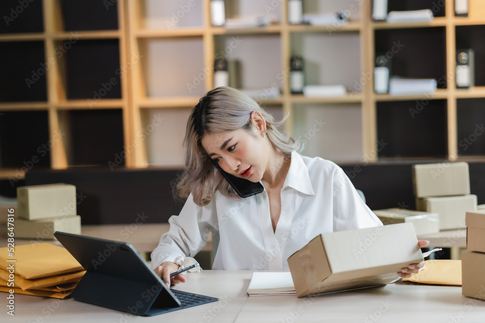 Asian woman sme entrepreneur startup e-business owner after checking order from online shopping delivery to customer success shopping small business. Asian woman sme entrepreneur startup e-business owner after checking order from online shopping delivery to customer success shopping small business.
