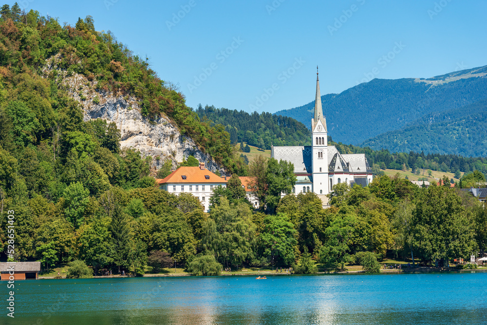 Lake Bled and Saint Martina Parish Church (zupnijska cerkev svetega Martina) in Gothic Revival or neo-Gothic style, 1903-1905. Gorenjska, Triglav National Park, Alps, Slovenia, central Europe.