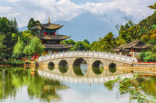 Scenic view of the Suocui Bridge over the Black Dragon Pool and the Moon Embracing Pavilion in the Jade Spring Park, Lijiang, China.