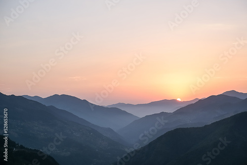 Smoky mountain sunset.Majestic autumn scenery of foggy valley at mountain range at early morning sunrise. Beautiful tonal perspective wide angle panorama