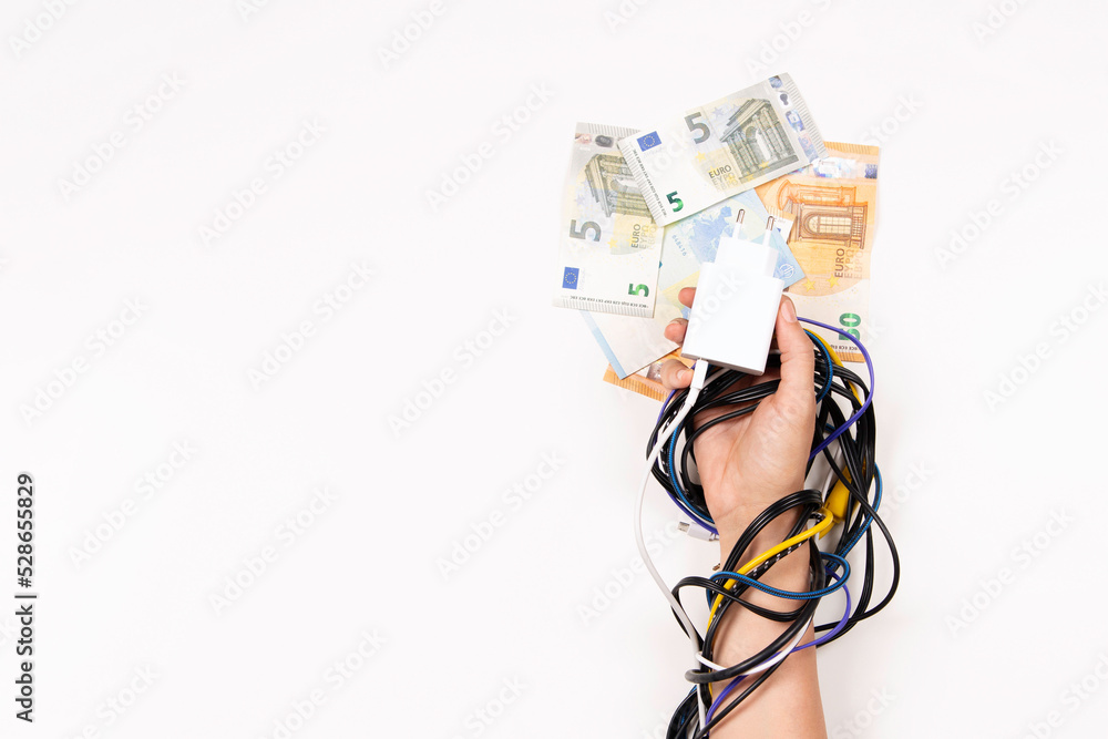 Female hand tied up with electric power cable cord on white background. Energy efficiency, power consumption, rising electricity price and expensive energy concept Female hand tied up with electric power cable cord on white background. Energy efficiency, power consumption, rising electricity price and expensive energy concept