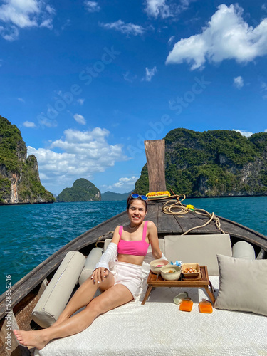 Woman tourist in private longtail boat trip to island with exotic food picnic, Krabi, Thailand. landmark, destination, Asia Travel, vacation, wanderlust and holiday concept