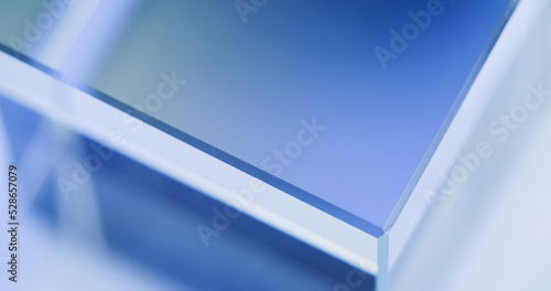 Neon illuminated background. Blur light. Glass cube angle. Defocused tranquil blue white color glow modern geometric abstract empty space poster for text.