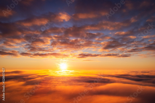 Beautiful landscape above the clouds of setting sun. Aerial photo of sun going under horizon, dream like atmosphere