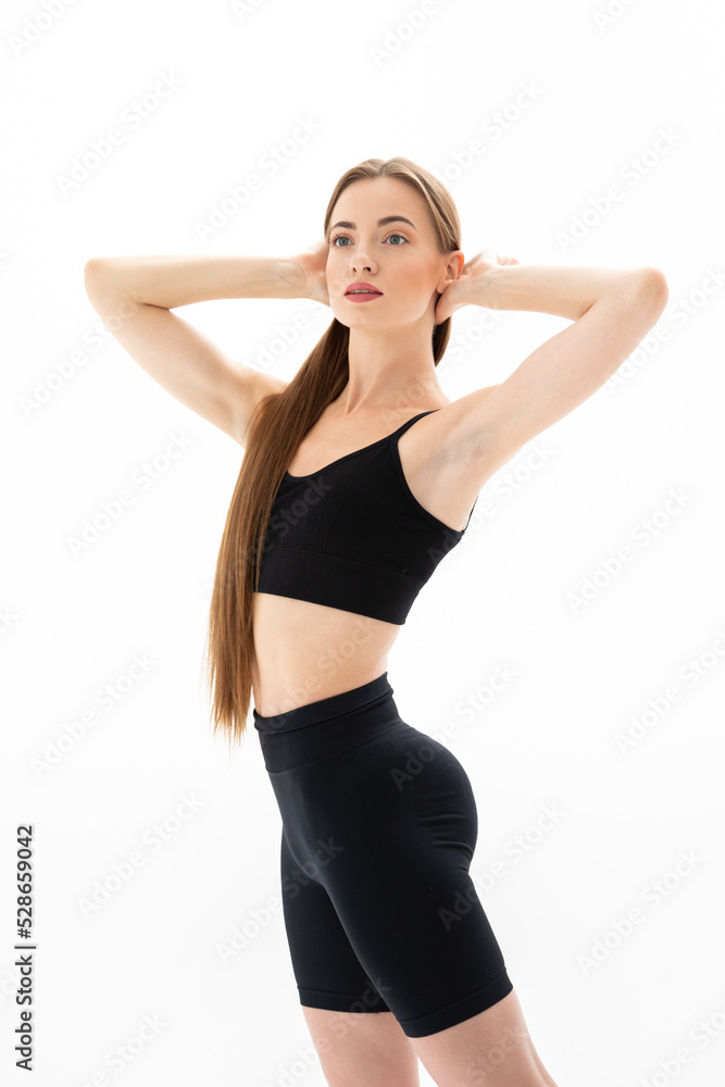 Slim sporty fitness young woman gymnast in sportswear training performs exercises on a white background Slim sporty fitness young woman gymnast in sportswear training performs exercises on a white background