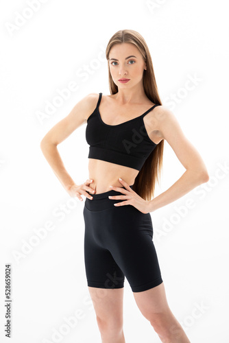 Slim sporty fitness young woman gymnast in sportswear training performs exercises on a white background © Andrei Pozharskiy