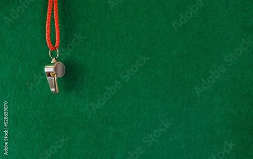 Whistle of soccer referee or trainer on green background. Great soccer event this year,template with large free copy space