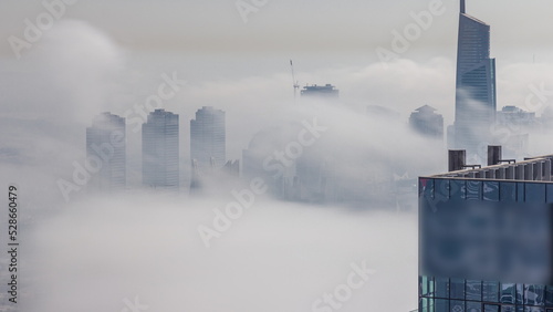 Fog covered skyscrapers in JLT district aerial timelapse.
