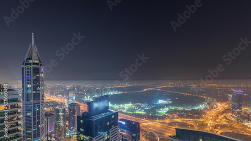Aerial skyline with Golf Club  hotels and residential areas far away in desert in Dubai all night timelapse  UAE  top view