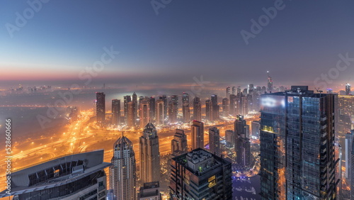 Panorama of Dubai Marina with JLT skyscrapers and golf course night to day timelapse, Dubai, United Arab Emirates. © neiezhmakov